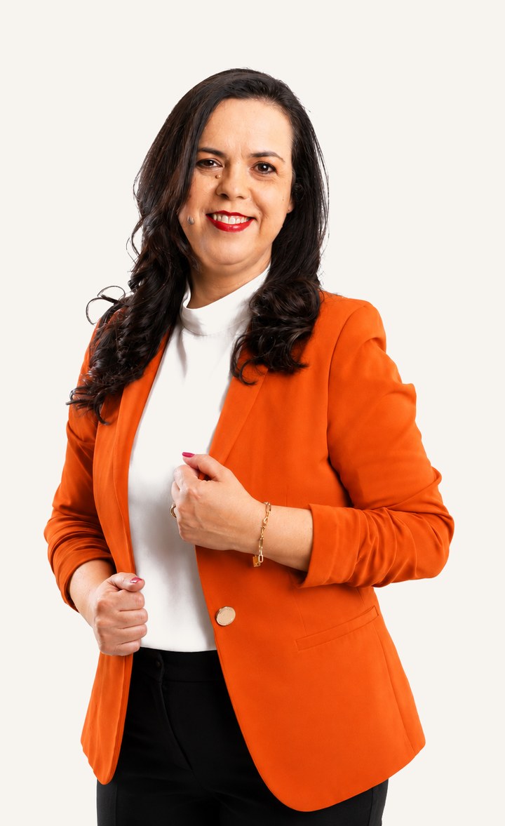 Kátia Gaivoto sorrindo, de blazer laranja