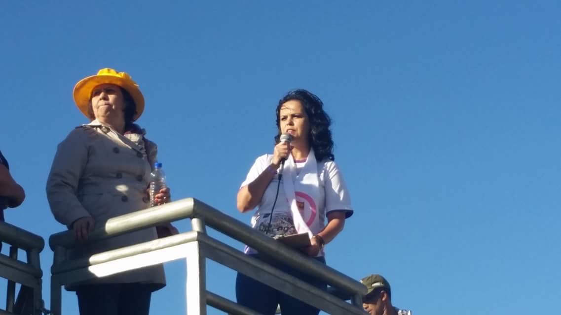 Kátia discursando ao microfone em ato de rua